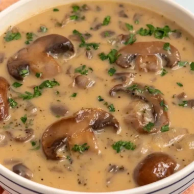 Bowl of Vegan Cream of Mushroom soup topped with fresh herbs