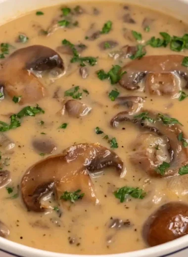 Bowl of Vegan Cream of Mushroom soup topped with fresh herbs