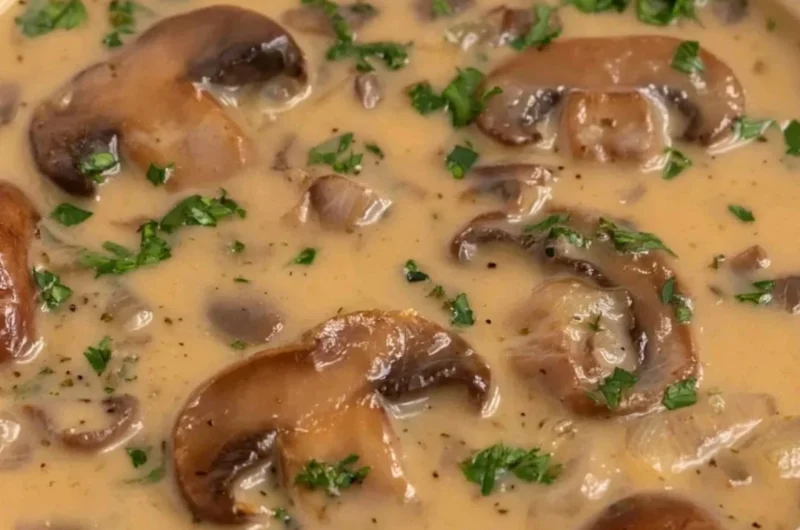 Bowl of Vegan Cream of Mushroom soup topped with fresh herbs
